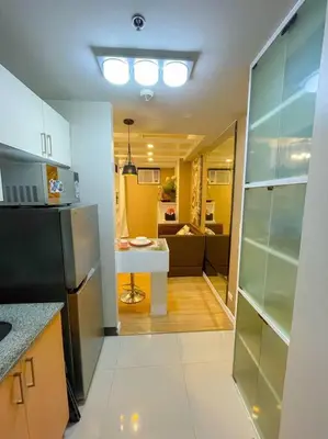 a kitchen with a refrigerator and a table in it at Deryll's Fun house in Manila