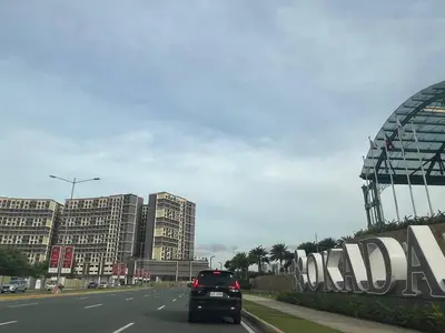 a car driving down a road in a city at Gentry Manor Balcony Green View WiFi Netflix Walk to Okada Casino 8J in Manila
