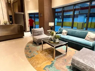 a lobby with a blue couch and a table and chairs at Gentry Manor Balcony Green View WiFi Netflix Walk to Okada Casino 8J in Manila