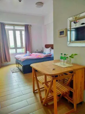 a room with a table and a bed and a bedroom at Jennie's 5m Suite in Manila