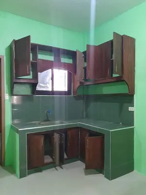 a kitchen with wooden cabinets and a sink at Casa Regine in Manila