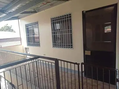 a balcony with a black door and two windows at Casa Regine in Manila