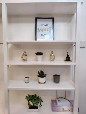 a white shelf with potted plants on it at Affordable Modern Studio with Netflix WiFi Balcony in Air Residences in Manila