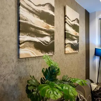 a living room with three paintings on the wall at Gabila Staycation at Azure in Manila