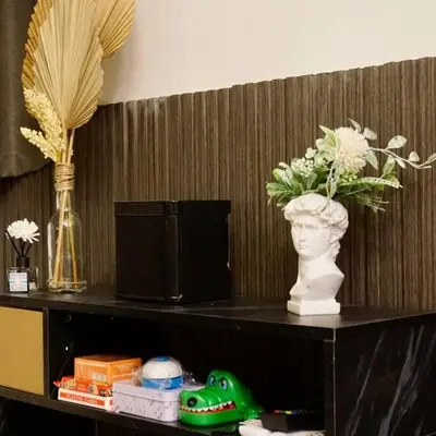a shelf with a vase and flowers on it at Gabila Staycation at Azure in Manila