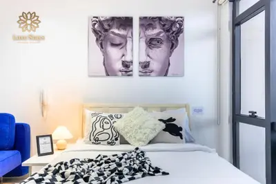a bedroom with a bed and a picture of a man at Affordable Staycation with Balcony at The Gramercy Makati in Manila