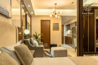 a bedroom with a bed and a living room at Luxurious 1BR Staycation at One Uptown BGC in Manila