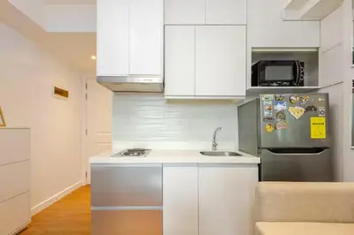 a kitchen with white cabinets and a stainless steel refrigerator at Dsa'sCrib 1BR Azure Near Airport in Manila