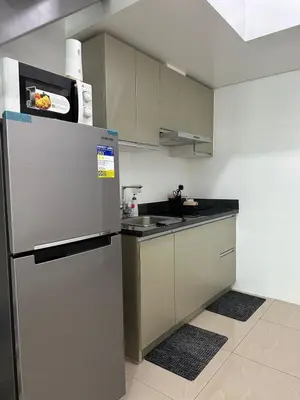 a kitchen with a stainless steel refrigerator and cabinets at 1bedroom LOFT with Garden Terrace pool access in Manila