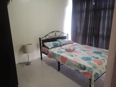 a bedroom with a bed and a lamp in it at Emjay's staycation in Manila