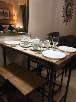a wooden table with plates and wine glasses on it at Infinity Stay in Manila
