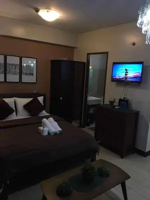 a bedroom with a bed and a flat screen tv at Infinity Stay in Manila