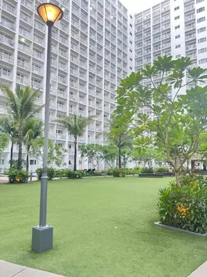 a light pole in a park with palm trees and buildings at Daisy's Suite by Staycation in Manila