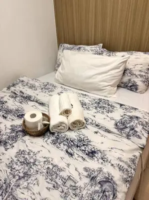 a bed with towels and a basket on it at Daisy's Suite by Staycation in Manila