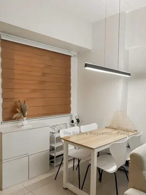 a dining room with a table and a wooden blind at 2BR The Blums at Prisma Residences in Manila