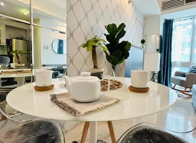 a white table with a tea set on top of it at BEAUTIFUL and SPACIOUS 2 REAL BEDROOMS 2 BATHROOMS IN BGC GLOBAL CITY in Manila
