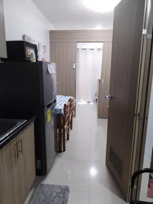 a kitchen with a black refrigerator and a table at Shore 2 Family Suite 2 Beds Balcony City View WiFi Netflix MOA 735 in Manila