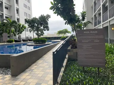 a sign in front of a building with a swimming pool at Shore 2 Family Suite 2 Beds Balcony City View WiFi Netflix MOA 735 in Manila