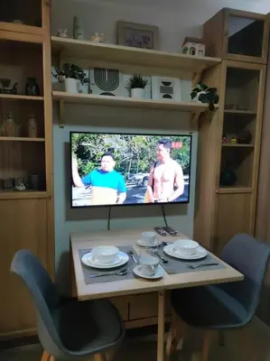 a television in a living room with a table and chairs at Casa Florentino in Manila