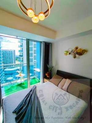 a bedroom with a large bed and a large window at CHILL City Escapes at Azure Urban Residences in Manila