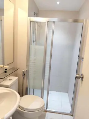 a bathroom with a shower and a toilet and a sink at CHILL City Escapes at Azure Urban Residences in Manila