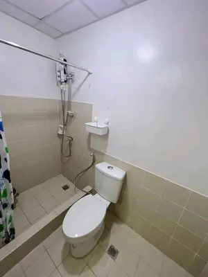 a bathroom with a white toilet and a shower at One taft residence taft avenue City Land manila in Manila