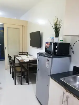 a kitchen and dining room with a table and a refrigerator at Sea residence Family Group Affordable staycation in Manila