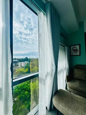 a room with a large window with white curtains at Enter Home McKinley with a View in Manila