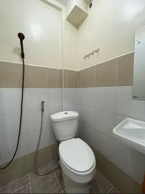 a bathroom with a toilet and a sink at Lawton Residences Studio Room 3K in Manila