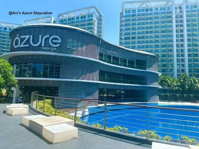 a building with a swimming pool in front of it at Azure Urban Resort Residences in Manila