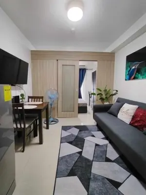 a living room with a couch and a table at Shore Residences - 1 Bedroom Condo Unit in Manila