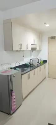a kitchen with white cabinets and a sink at Derick Staycation With Balcony Moa View in Manila