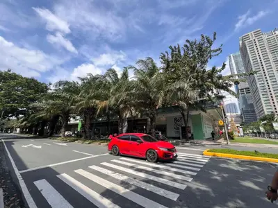 a red car parked on a street with a crosswalk at Ortigas Greenfield Cozy Lodge in Manila
