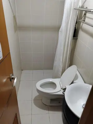 a small bathroom with a toilet and a sink at Ortigas Greenfield Cozy Lodge in Manila