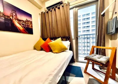 a small bedroom with a bed and a window at SMDC FAME apartment in Ortigas in Manila