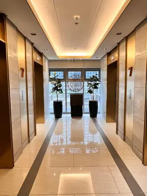 a hallway with two potted trees in a building at Heart of Ortigas Center in Manila