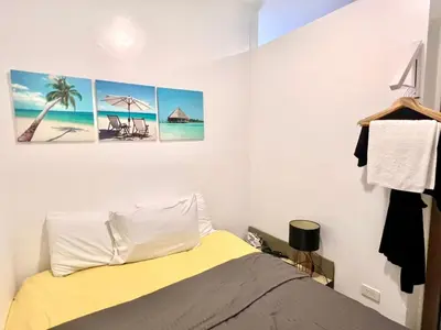 a bedroom with a bed and some pictures on the wall at Heart of Ortigas Center in Manila