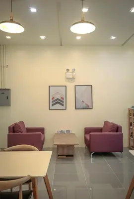a waiting room with two purple couches and a table at A Scandinavian-inspired studio in Silang in Bayabasan