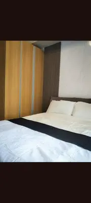 a bedroom with a large white bed with wooden walls at One Winstar Realty Corp in Manila