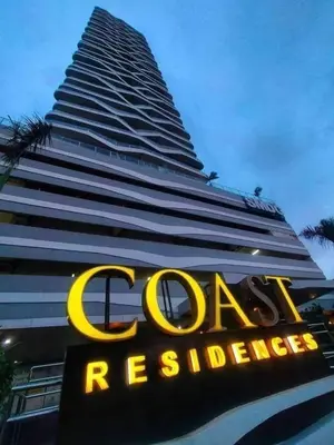 a large building with a sign in front of it at Condo next door in Manila