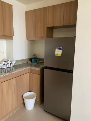a kitchen with a stainless steel refrigerator and wooden cabinets at Fairlane Residences in Manila