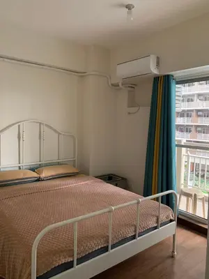 a bedroom with a bed and a window at Fairlane Residences in Manila
