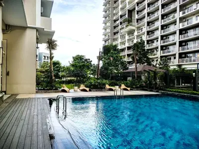 a swimming pool with chairs and a large building at Fairlane Residences in Manila