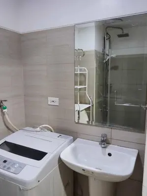 a white bathroom with a sink and a mirror at Near MOA at SHORE RESIDENCES 1BR with balcony -unlimited WIFI in Manila