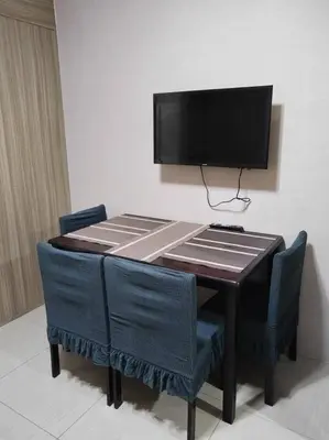 a wooden table with chairs and a television on a wall at Near MOA at SHORE RESIDENCES 1BR with balcony -unlimited WIFI in Manila