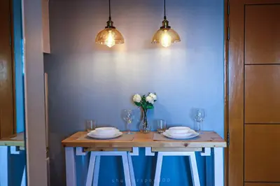 a table with plates and glasses and a vase of flowers at Best Deal! Cozy and Minimalist 2BR nr Airport in Manila
