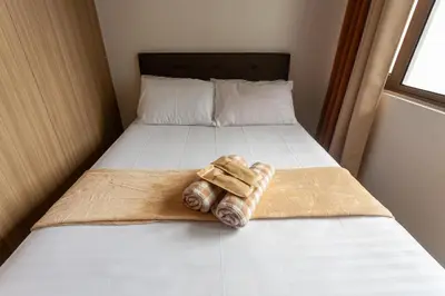 a pair of folded towels sitting on a bed at Shore Residences Tower D - Two Bedroom with Balcony in Manila