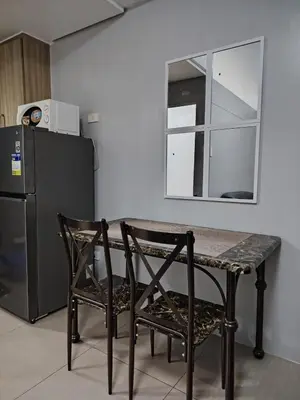 a kitchen with a table and two chairs and a refrigerator at Shore Residences Tower D - Two Bedroom with Balcony in Manila