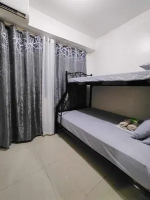 a bedroom with two bunk beds and a window at Shore 1 Residences - 1 Bedroom with Balcony in Manila
