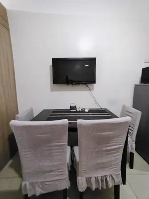 a black table with chairs and a television on a wall at Shore 1 Residences - 1 Bedroom with Balcony in Manila